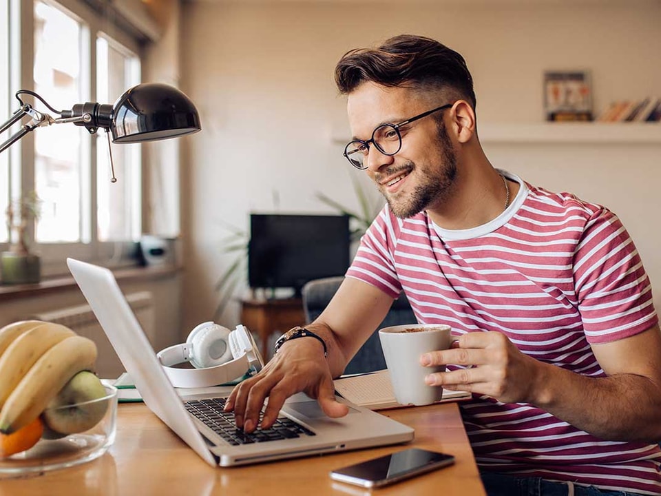 Mann drikker kaffe og ser på pc, illustrasjon til sparing